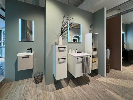 Modernes Badezimmer mit weißem Hängewaschbecken, rechteckigem Spiegel und neutraler Farbpalette.